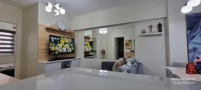 a living room with a couch and a tv in it at A cozy 2 bedroom condo in Metro in Manila
