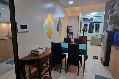 a kitchen and dining room with a table and chairs at Kan Emilio Cozy 1BR Apartment in Makati in Manila