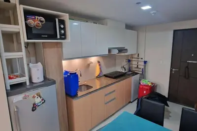 a small kitchen with a sink and a refrigerator at Kan Emilio Cozy 1BR Apartment in Makati in Manila
