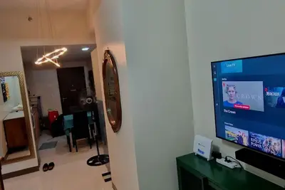 a living room with a flat screen tv on a wall at Kan Emilio Cozy 1BR Apartment in Makati in Manila