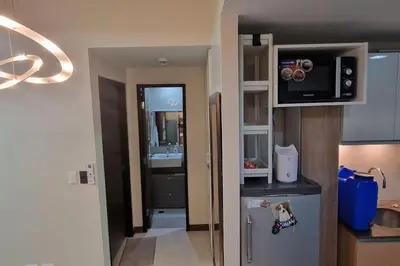 a small kitchen with a refrigerator and a sink at Kan Emilio Cozy 1BR Apartment in Makati in Manila