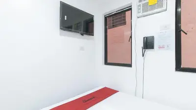 a room with a bed and a tv on a wall at RedDoorz @ El Grande Inn Santa Cruz Manila in Manila