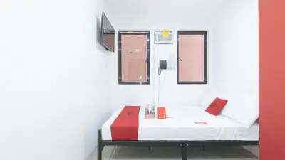 a bed in a room with a red and white at RedDoorz @ El Grande Inn Santa Cruz Manila in Manila
