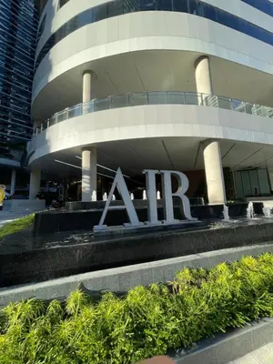a large building with a sign in front of it at Muji-Inspired hōme-tél in the heart of Makati in Manila