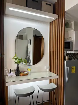 a kitchen with a counter with two stools and a mirror at Muji-Inspired hōme-tél in the heart of Makati in Manila