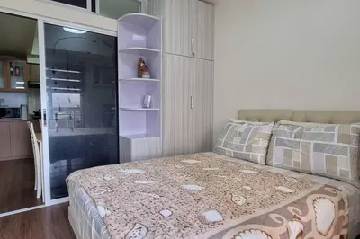 a small bedroom with a bed and a kitchen at Apartment in Pasig in Manila