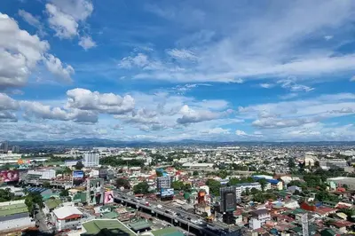 a view of a city with buildings and clouds at Apartment in Pasig in Manila