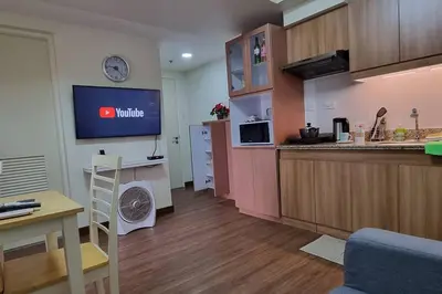 a room with a kitchen with a counter and a tv at Apartment in Pasig in Manila