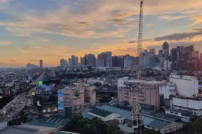a view of a city with buildings and a crane at Apartment in Pasig in Manila