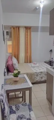 a living room with a bed and a table in a room at JJMC HOMESTAY 36 With Netflix and Unli Wifi in Manila