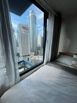 a bedroom with a view of a city from a window at Hygge home with Ayala CBD Makati view! NEW! in Manila