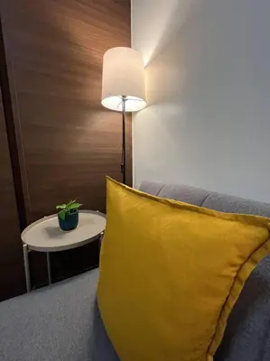 a yellow pillow in a room with a lamp and a table at Hygge home with Ayala CBD Makati view! NEW! in Manila