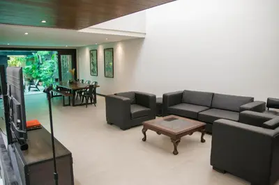 a living room with couches and a coffee table at Tropical Poolhouse QC in Manila