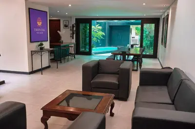 a living room with a couch and a table at Tropical Poolhouse QC in Manila