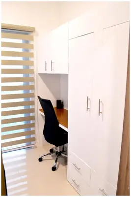 an office with a black chair and a desk at Iona Reign's Vacation Unit at FAME Residences in Manila