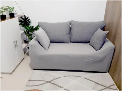 a couch in a living room with pillows on it at Iona Reign's Vacation Unit at FAME Residences in Manila