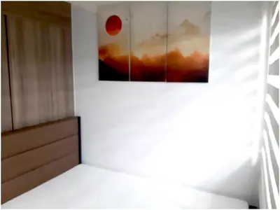a room with a painting hanging on the wall at Iona Reign's Vacation Unit at FAME Residences in Manila