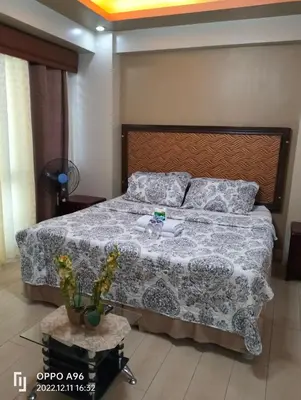 a bedroom with a large bed with a blanket and pillows at CondoTel Pasay Newport City in Manila