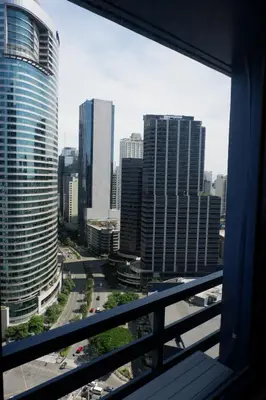 a view from a window of a city with tall buildings at Homey 1 Bedroom Unit at Air Residences in Manila