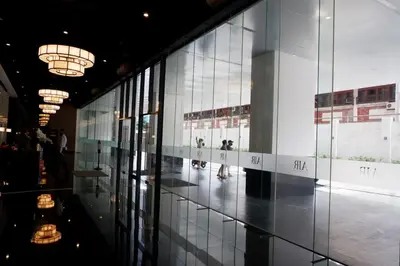 a building with glass walls and a hallway with people in it at Homey 1 Bedroom Unit at Air Residences in Manila