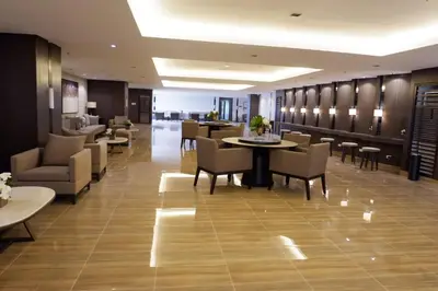a lobby with tables and chairs and a restaurant at Homey 1 Bedroom Unit at Air Residences in Manila