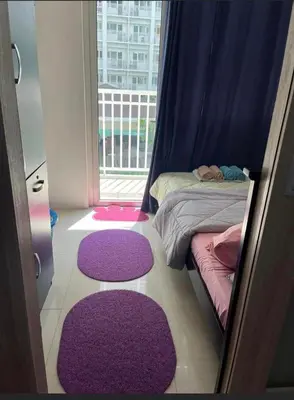 a bedroom with purple rugs on the floor and a window at Shore 1 Residences Staycation By Ms Chona in Manila
