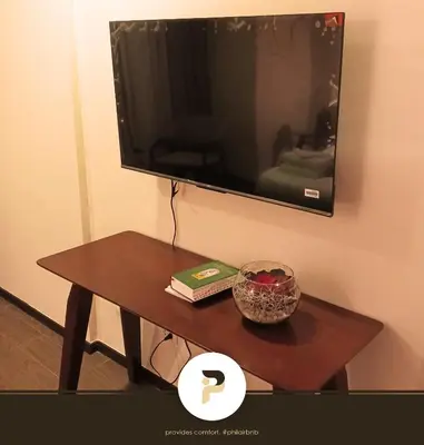 a table with a tv and a book on it at FULLY FURNISHED STUDIO NEAR MOA in Manila
