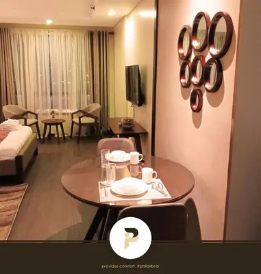 a hotel room with a table and a room at FULLY FURNISHED STUDIO NEAR MOA in Manila