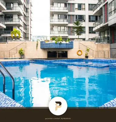 a large blue swimming pool in front of a building at FULLY FURNISHED STUDIO NEAR MOA in Manila