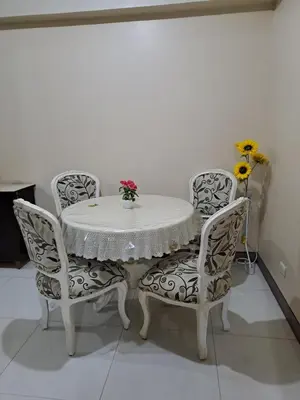 a white table and chairs with a white table and flowers at MRMCONDOTEL in Manila