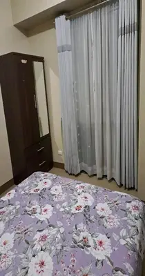 a bedroom with a purple bed with flowers on it at MRMCONDOTEL in Manila