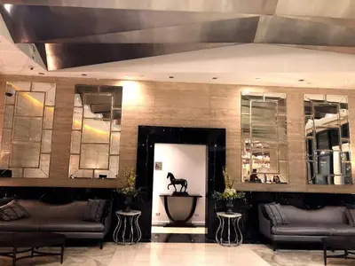 a lobby with couches and a horse statue on the wall at the Gramercy Residences in Manila