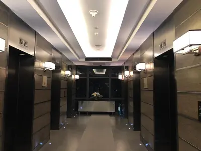a hallway in a hotel with a table and lights at the Gramercy Residences in Manila