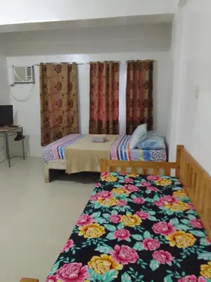 a bedroom with two beds and a bedspread with flowers at La Casa Hungary 109 Kassel Residences Near NAIA in Manila