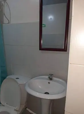 a bathroom with a sink and a toilet and a mirror at La Casa Hungary 109 Kassel Residences Near NAIA in Manila