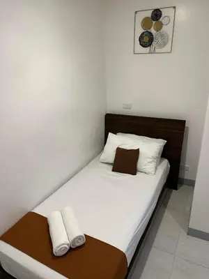 a bed in a room with two towels on it at Aden Hotel in Manila