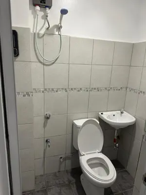 a bathroom with a shower and a toilet and a sink at Aden Hotel in Manila
