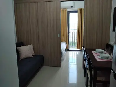 a living room with a couch and a dining table at Cozy22 1BR at Shore2 Tower2 in Manila