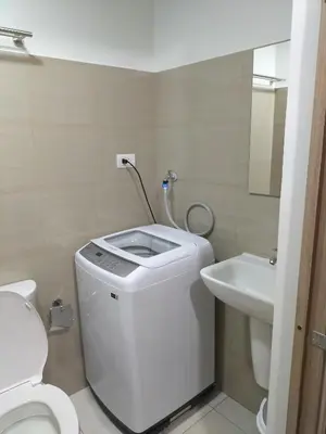 a white bathroom with a toilet and a sink at Cozy22 1BR at Shore2 Tower2 in Manila