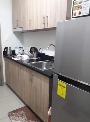 a kitchen with a stainless steel refrigerator and a sink at Cozy22 1BR at Shore2 Tower2 in Manila