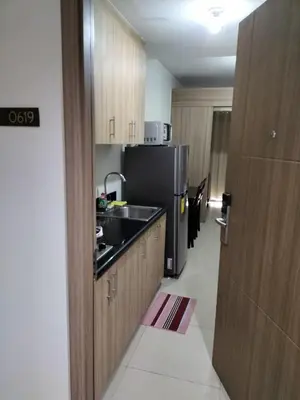 a kitchen with a sink and a black refrigerator at Cozy22 1BR at Shore2 Tower2 in Manila