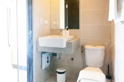 a bathroom with a white sink and a toilet at Uptown Parksuites Apartments Tower 2 BGC by PH Staycation in Manila