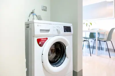 a washing machine in a room with a table at Uptown Parksuites Apartments Tower 2 BGC by PH Staycation in Manila