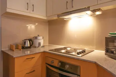 a kitchen with a stove top oven next to a microwave at Uptown Parksuites Apartments Tower 2 BGC by PH Staycation in Manila