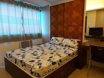 a small bedroom with a bed and a desk at Romantic 1 Bedroom with Pool in Manila