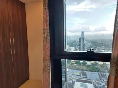 a window in a room with a view of a city at Romantic 1 Bedroom with Pool in Manila