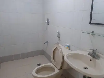 a bathroom with a toilet and a sink at Comfy Bunkbed with Pool in Manila