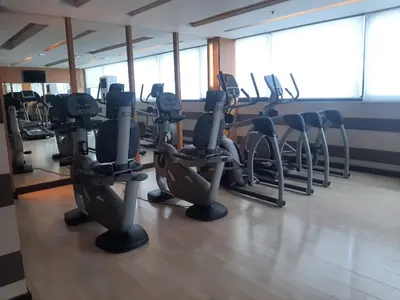 a gym with rows of treadmills and elliptical machines at Comfy Bunkbed with Pool in Manila