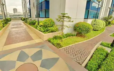 a courtyard in a building with plants and trees at Comfy Bunkbeds at BSA in Manila