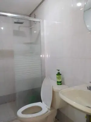 a bathroom with a toilet and a sink at Comfy Bunkbeds at BSA in Manila